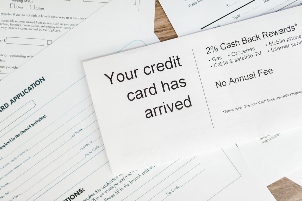 Close-up of a letter announcing the arrival of a credit card amidst financial documents.